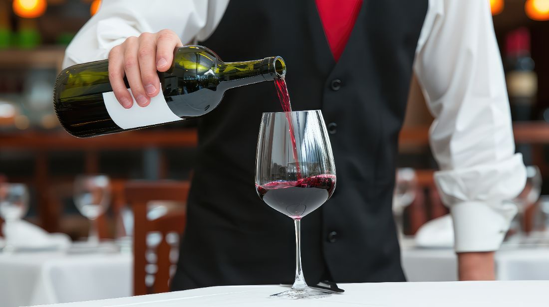 Sommelier servindo vinho tinto na mesa