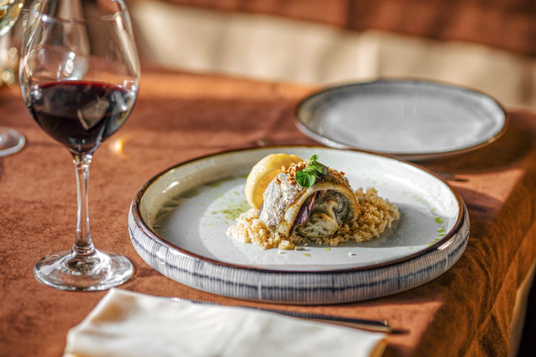 Prato de peixe finalizado com quinoa e vinho tinto
